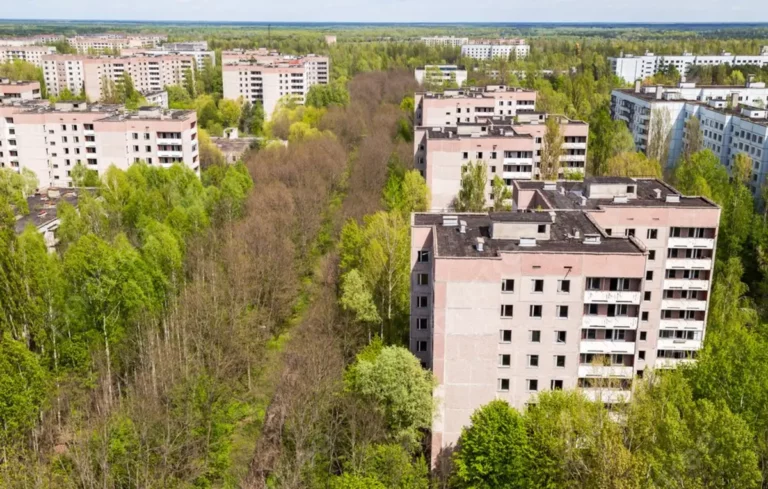 Vista aérea da cidade de Pripyat, mostrando prédios abandonados, ruas vazias e vegetação invadindo as estruturas dentro da zona de exclusão de Chernobyl.