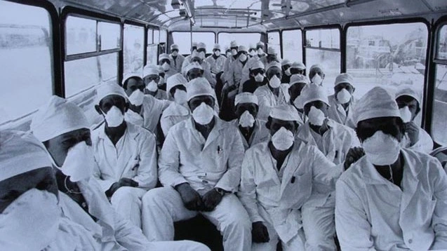 Fotografia histórica dos liquidadores de Chernobyl usando equipamentos de proteção rudimentares enquanto limpam detritos radioativos próximos ao reator.